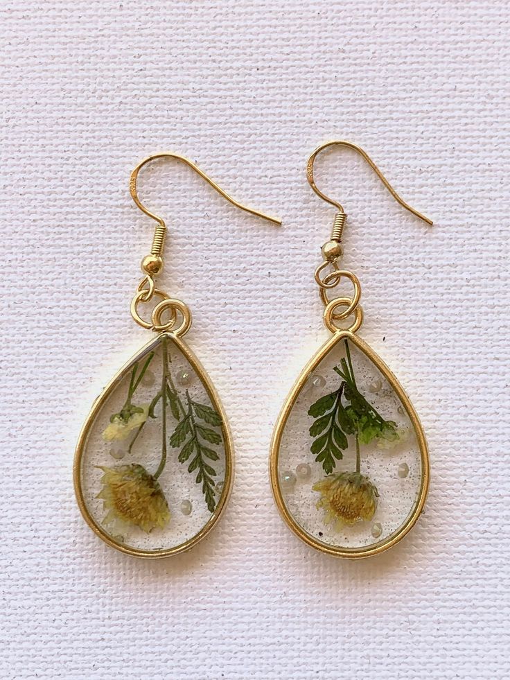 Experience the enchantment of nature with our pressed flower earrings. Each delicate petal preserved in resin exudes timeless beauty and elegance. Add a touch of floral grace to your ensemble. 🌸✨ Botanical Jewelry With Pressed Flowers, Elegant Resin Earrings With Flower Charm, Nature-inspired Teardrop Earrings With Pressed Flowers, Botanical Drop Earrings With Birth Flower, Botanical Flower Earrings With Birth Flower, Nature-inspired Teardrop Birth Flower Earrings, Botanical Birth Flower Drop Earrings, Nature-inspired Flower Earrings With Birth Flower Detail, Elegant Resin Earrings With Pressed Flowers