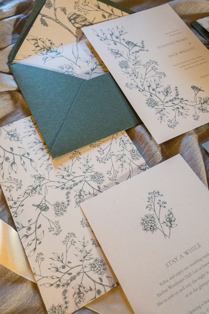 the wedding stationery is laid out on top of each other, with matching envelopes