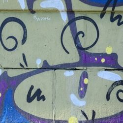 graffiti on the side of a building with blue and purple designs painted all over it