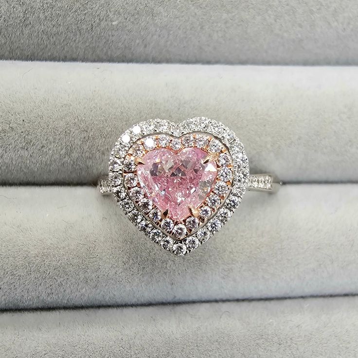 a pink heart shaped diamond ring on display