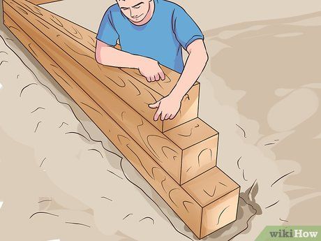 a man laying on top of wooden planks with his hands resting on the edge