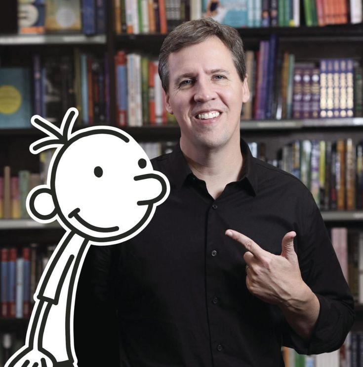 a man standing in front of a book shelf with a sticker on it