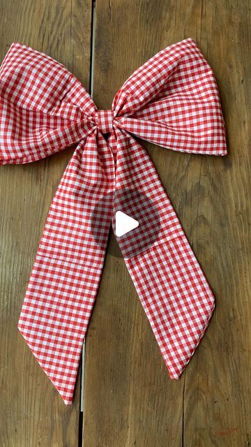 a red and white checkered bow tied to a wooden table