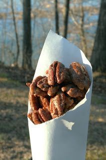 a paper bag filled with donuts sitting on top of a wooden table in the woods