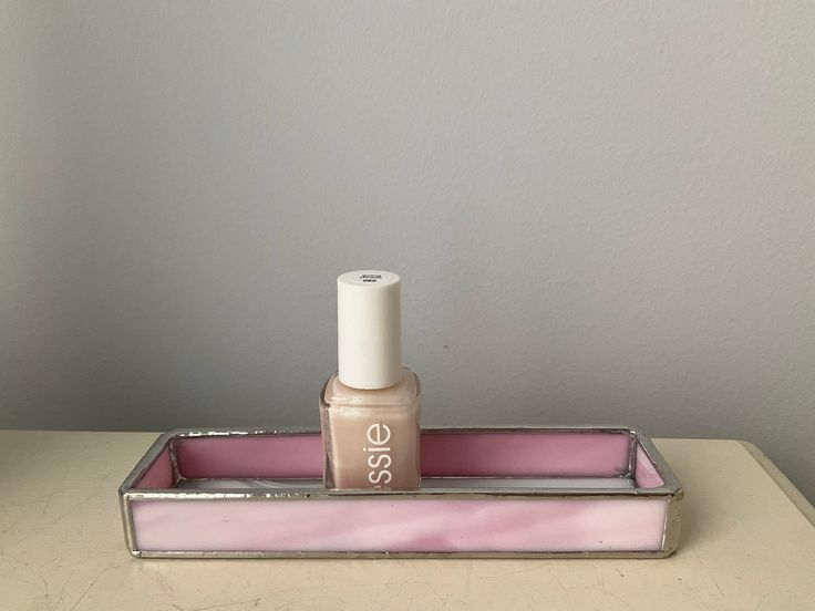 A small tray made to hold your nail polish, or small cosmetic bottle.  This small size is ideal for small countertops or to put in your bathroom cabinet drawer. A variegated pink sides and white swirl bottom make up this pretty tray.      All pieces have been copper foiled and soldered with a silver patina.  The tray measures approximately 6 inches long by 1-1/2 inches wide by 3/4 inch in height. All sides are shown shown. Protective bumpers will be added to the tray to keep the tray from slippi Pink Tray, Nail Polish Holder, Small Tray, Cosmetic Bottles, Small Bottles, Bathroom Cabinet, Cabinet Drawer, Bottle Holder, Bottle Holders