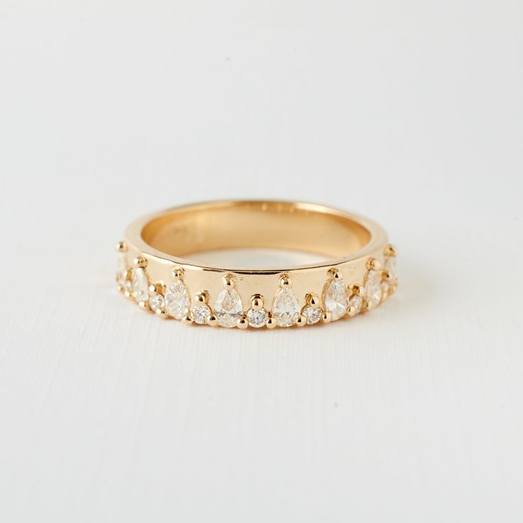 a yellow gold ring with five pear shaped diamonds