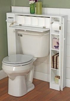 a white toilet sitting in a bathroom next to a book shelf