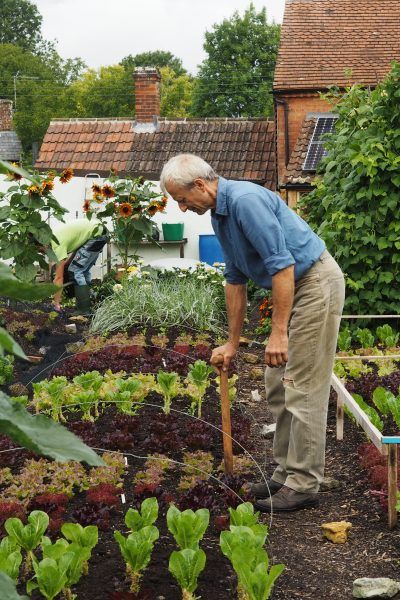 an older man is tending to his garden