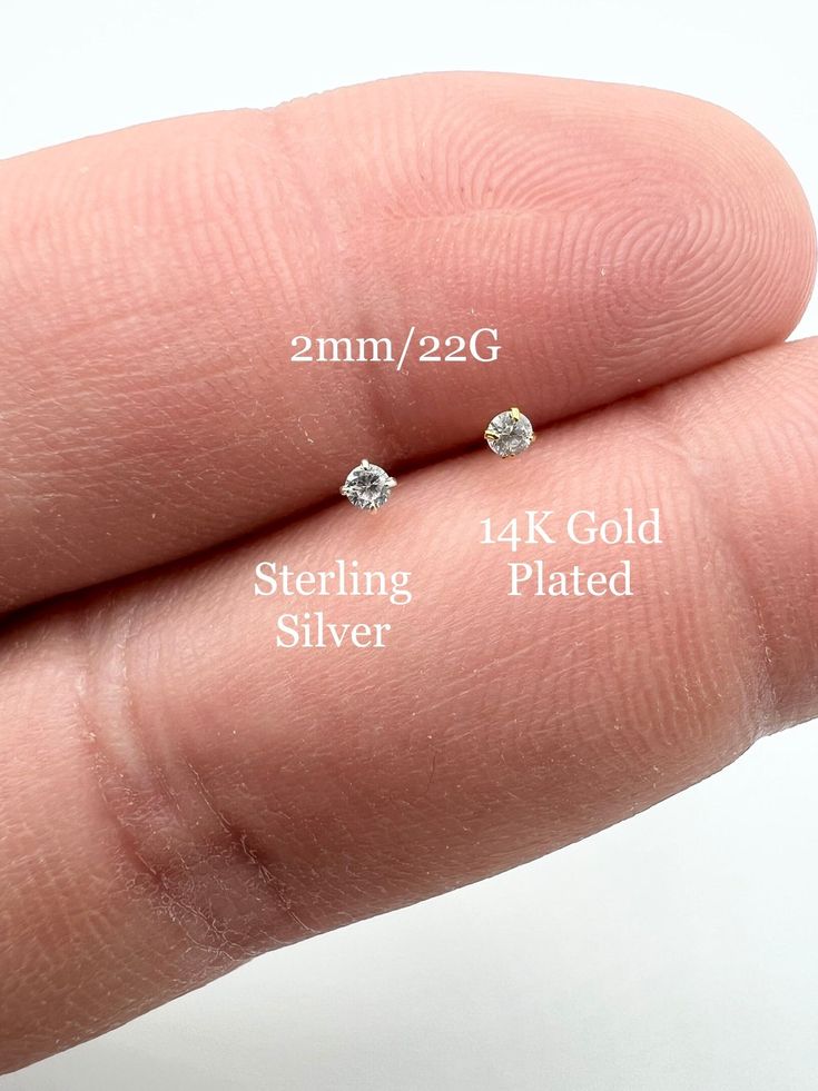 three different sizes of diamond studs on someone's finger, with the size shown below them