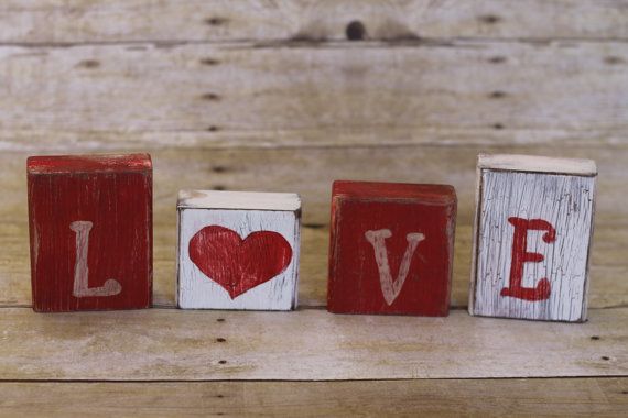 three wooden blocks with the word love painted on them