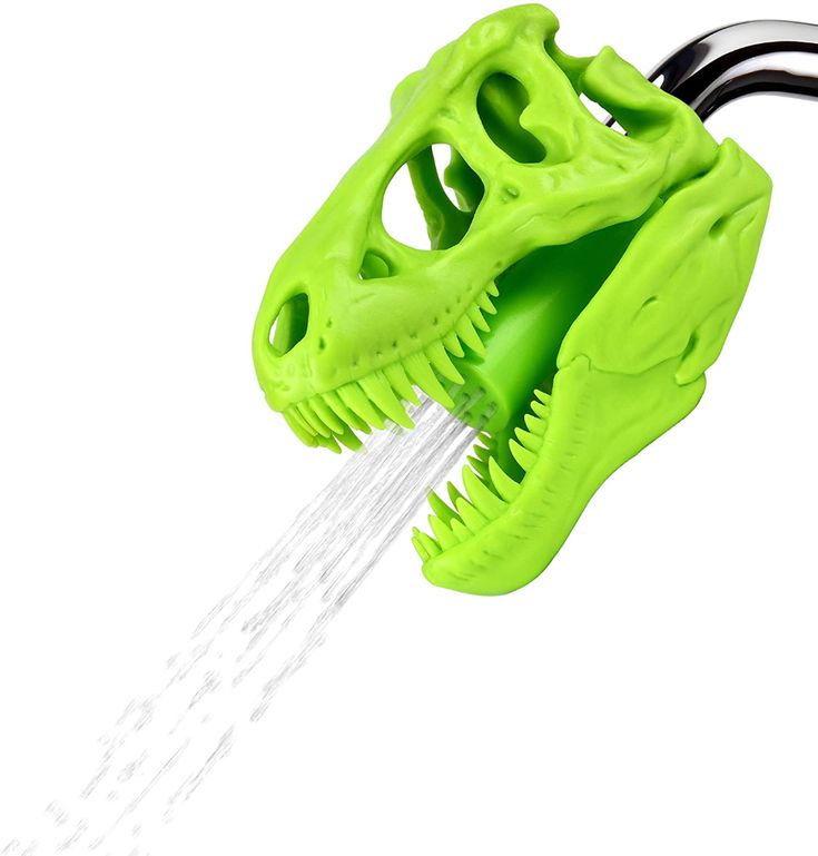 a green dinosaur toothbrush with water coming out of it's mouth and spouting