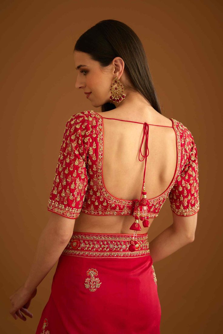 Editor's Note The combination of a red brocade blouse with zardozi embroidery and a silk chanderi sari with zardozi embroidery creates a stunning traditional look. The blouse adds a pop of bold color with intricate detailing, while the sari adds elegance with delicate embroidery. Color: Red Fabric: Silk and chanderi Embroidery details: Zardozi embroidery Components: Sari & blouse Sari length: 6 meters, sari width: 46" inches Occasion: Engagement and wedding guest Disclaimer: Product color may sl Trendy Blouse Designs Silk Saree, Red Blouse Combination Saree, Red Embroidery Blouse, Fancy Blouse Back Designs, Bollywood Embroidered Choli For Transitional Season, Transitional Bollywood Embroidered Choli, Embroidered Banarasi Silk Choli For Navratri, Embroidered Dola Silk Choli For Traditional Ceremonies, Red Color Blouse Designs Latest