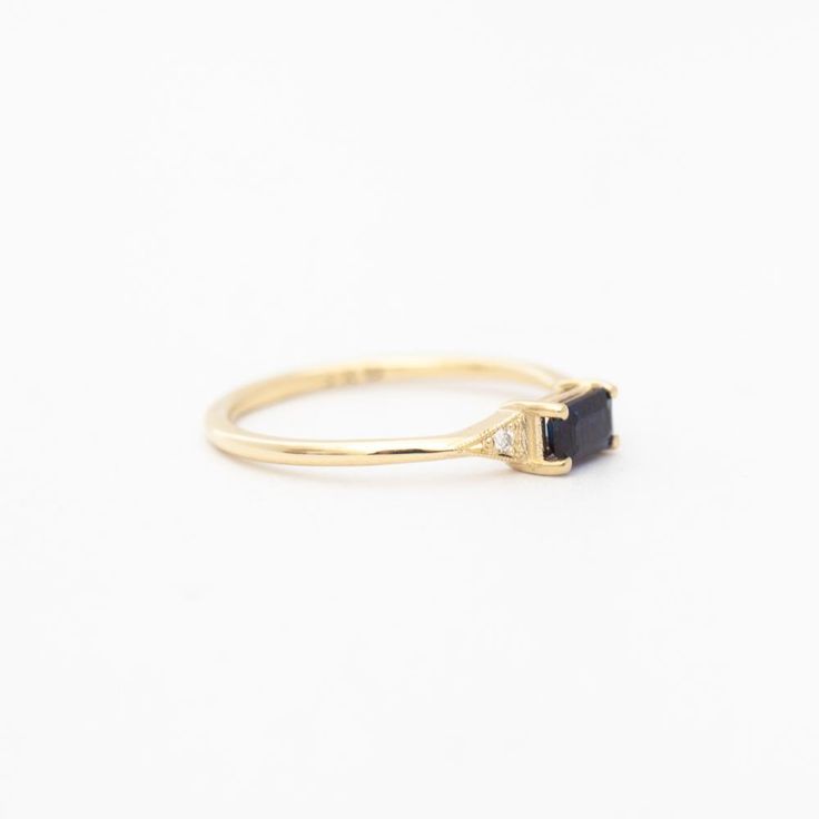 A azure blue sapphire set in Jennie Kwon's signature deco setting makes for a perfectly balanced piece that's deliciously dainty. Wear her as an alternative bridal ring—or on any finger, just because. Made in the U.S.A. 14 karat gold set with one 5 mm x 3 mm blue sapphire and two 1.2 mm diamonds. Timeless Lab-created Sapphire Promise Ring, Timeless Sapphire Rings With Lab-created Sapphire, Timeless Sapphire Ring With Diamond For Gift, Timeless Sapphire Promise Ring With Prong Setting, Classic Sapphire Baguette Cut Ring, Heirloom Sapphire Birthstone Promise Ring, Classic Sapphire Birthstone Ring With Gemstone, Emerald Cut Sapphire Solitaire Promise Ring, Emerald Cut Solitaire Sapphire Promise Ring