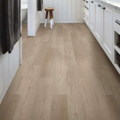 a kitchen with white cabinets and wood floors