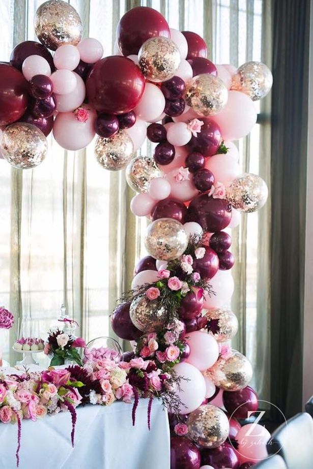 a table topped with lots of balloons and flowers