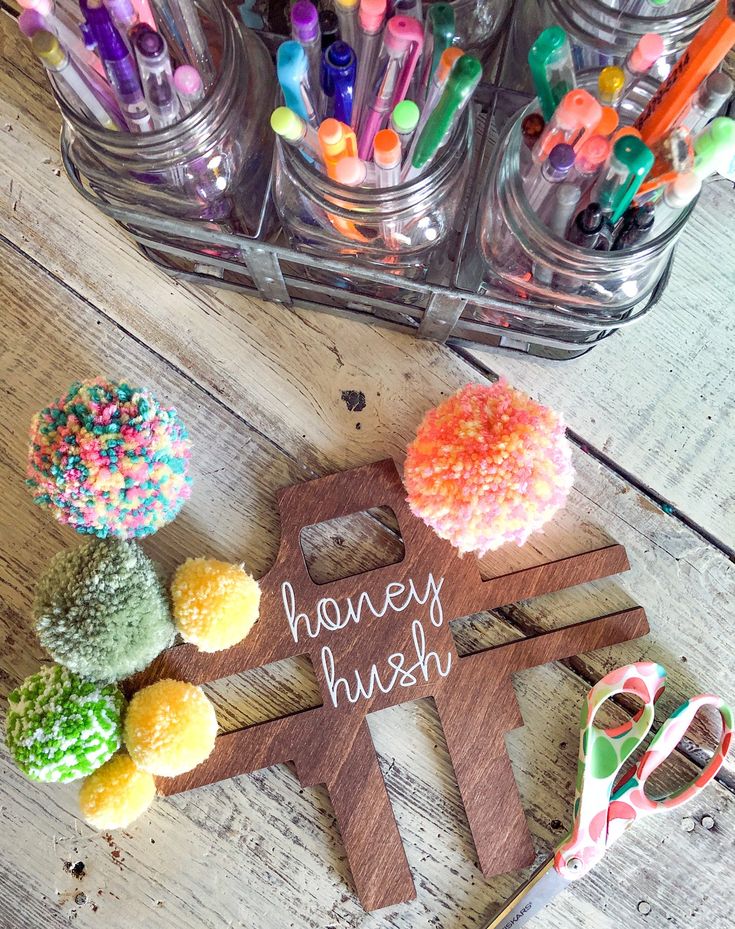 a wooden sign sitting on top of a table next to cupcakes and candy