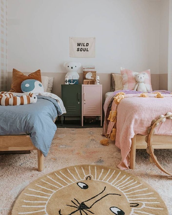 a bedroom with two beds and a rug on the floor in front of them,