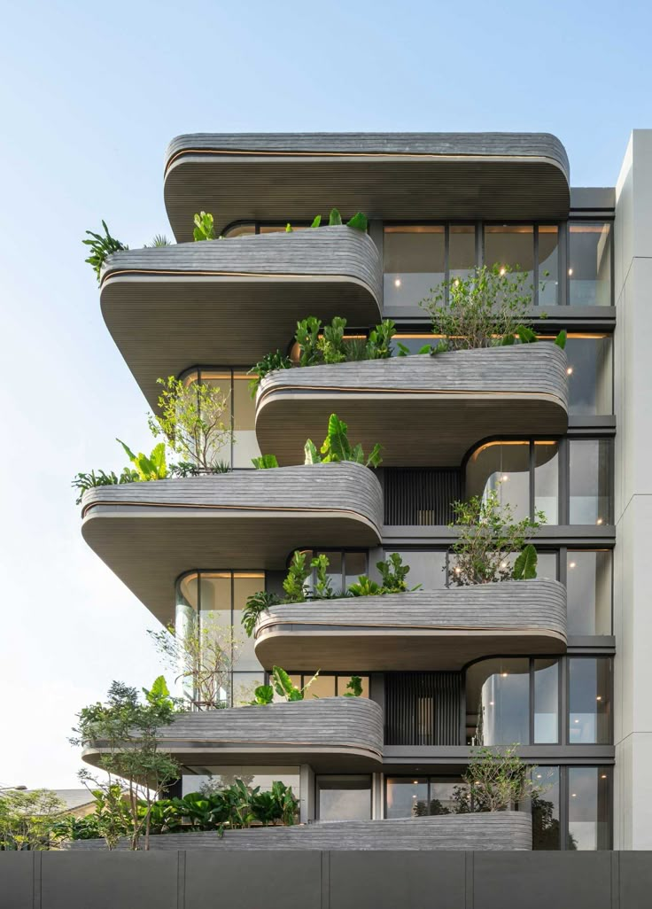 an apartment building with plants growing on the balconies