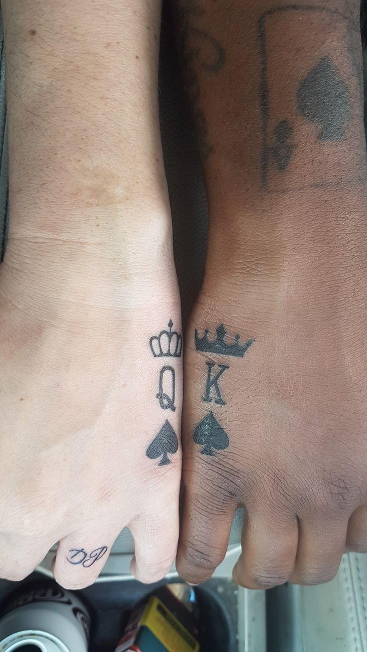 two people with tattoos on their feet holding each other's hands and one has a king and queen tattoo