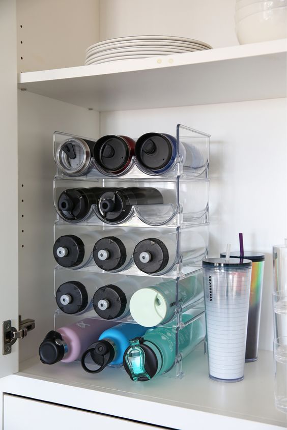 there are many cups and containers on the shelf