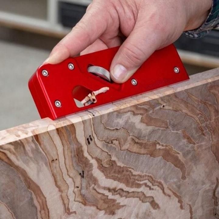 a person holding a red object in their hand on top of a marble countertop