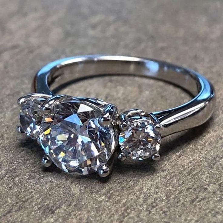 three stone diamond ring sitting on the ground