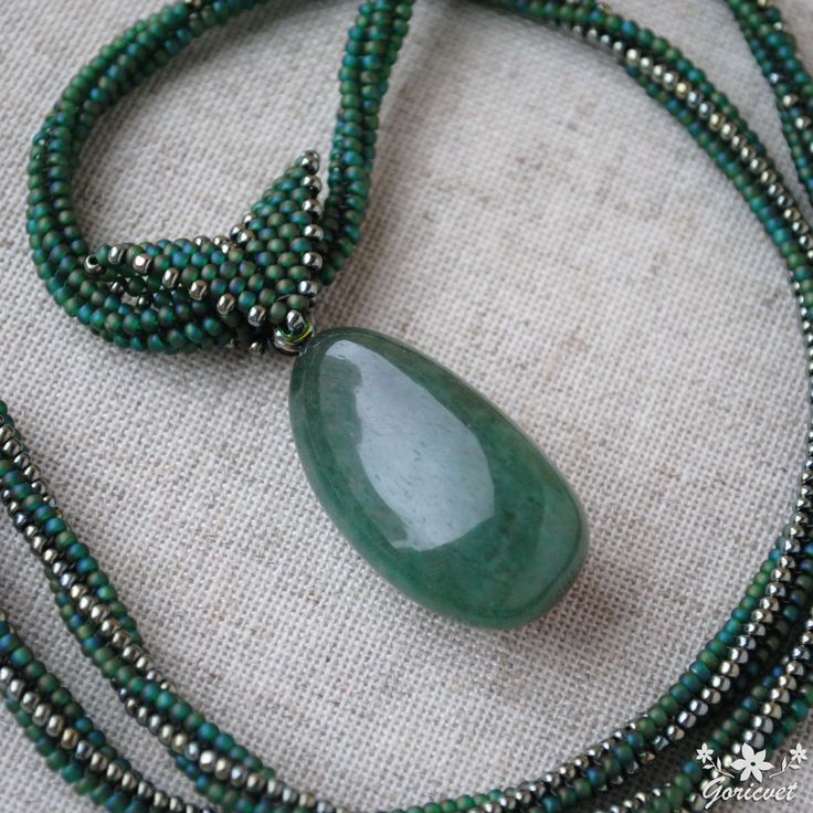 This boho jade pendant necklace is made with Japanese Toho seed bead and drop nephrite. This large jade pendant on hand woven bead necklace is a nice gift for women any occasion. Properties of balance stone used in boho necklace: Jade: This stone has powerful effects on heart chakra and love. It helps to stop inner sabotage and also it makes stronger the feelings of self love and self worth. It also helps to be calm and peaceful. Length of beaded rope necklace is approx. 60 cm (23.62 inch). Size of drop nephrite pendant with beaded bale is approx. 50 mm (1.97 inch) x 18 mm (0.71 inch). Size of drop nephrite: 35 mm (1.38 inch) x 18 mm (0.71 inch). Your large jade necklace will be wrapped up in a beautiful organza bag and craft box. Thank you very much for purchasing and visiting my shop! Adjustable Beaded Necklace With Teardrop Pendant, Handmade Teardrop Bohemian Beads, Artisan Beaded Teardrop Necklaces, Handmade Green Crystal Long Necklace, Bohemian Teardrop Beaded Necklaces With Adjustable Fit, Artisan Teardrop Beaded Necklace, Bohemian Teardrop Beaded Necklaces, Bohemian Teardrop Beaded Necklaces For Jewelry Making, Bohemian Teardrop Beads For Jewelry Making