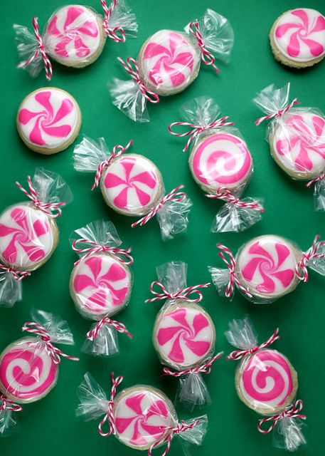 pink and white lollipops wrapped in clear cellophane on green background