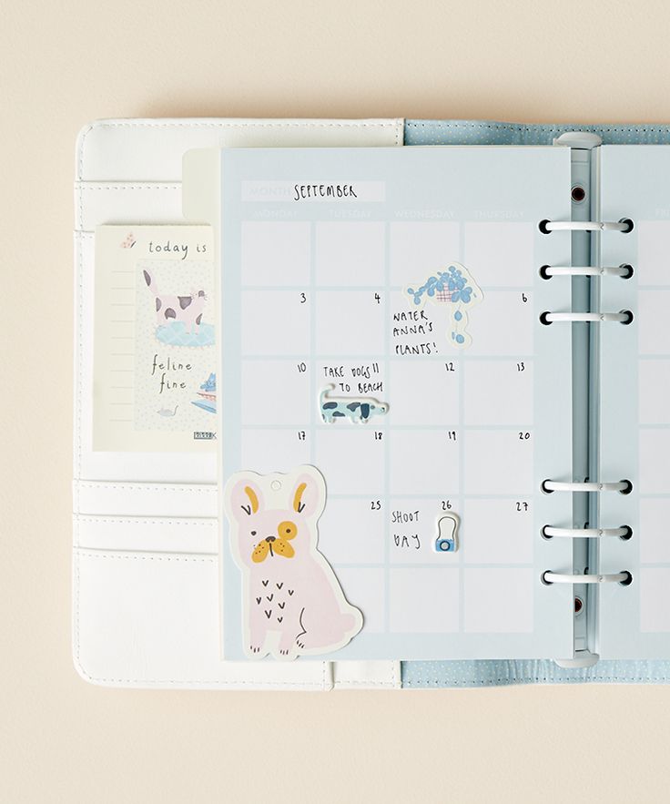 an open planner book with stickers on the pages and a clipboard attached to it