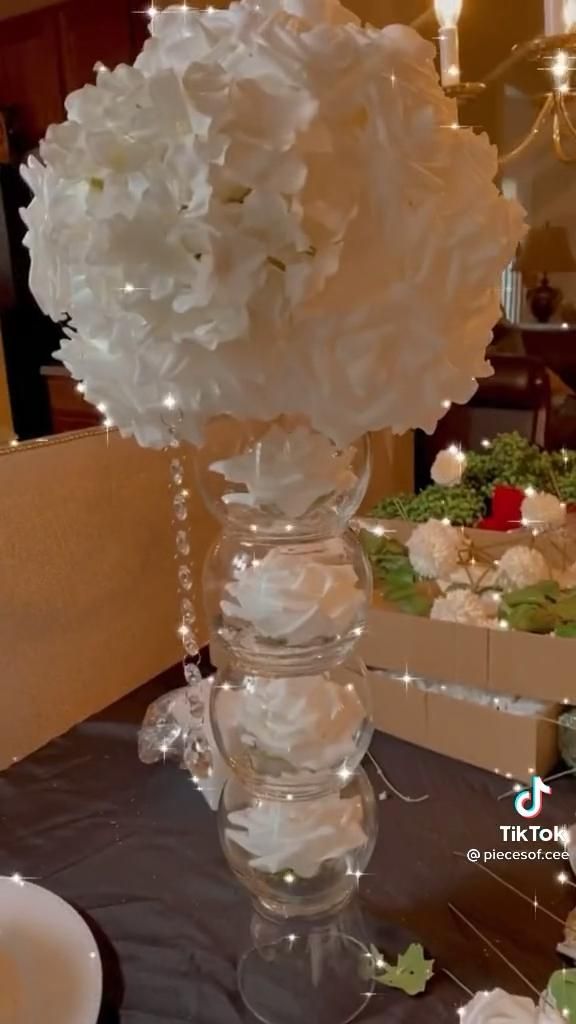 a vase filled with white flowers sitting on top of a table next to a box