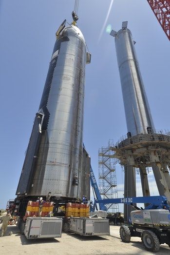 two large metal silos sitting next to each other on top of a dirt field