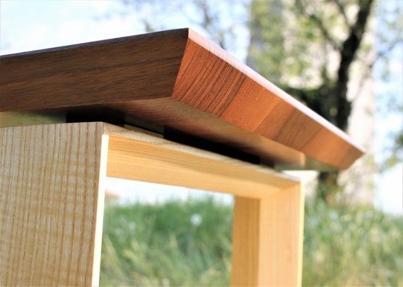 a close up of a wooden bench with grass in the background