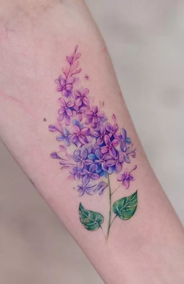 a purple flower tattoo on the arm