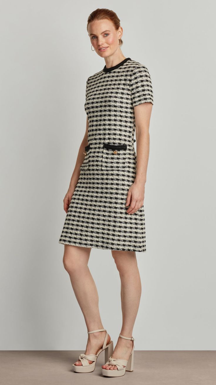 Exuding modern sophistication and classic elegance, the Lily dress features a stylish houndstooth boucle fabric, trimmed pockets, and glittering golden buttons. The effortlessly chic mid-length design is sure to turn heads in any setting, from the boardroom to the cocktail lounge - making a timelessly tasteful impression on all who behold it. Boucle Fabric Back Zipper Closure Front Pocket Buttons Chic Houndstooth Tweed Dress For Work, Chic Tweed Workwear Dresses, Black Houndstooth Tweed Dress For Work, Black Tweed Houndstooth Dress For Workwear, Fitted Tweed Dress With Houndstooth Pattern For Formal Occasions, Formal Fitted Tweed Dress With Houndstooth Pattern, Classic Tweed Dresses For Work, Knee-length Tweed Office Dress, Office Knee-length Tweed Dress