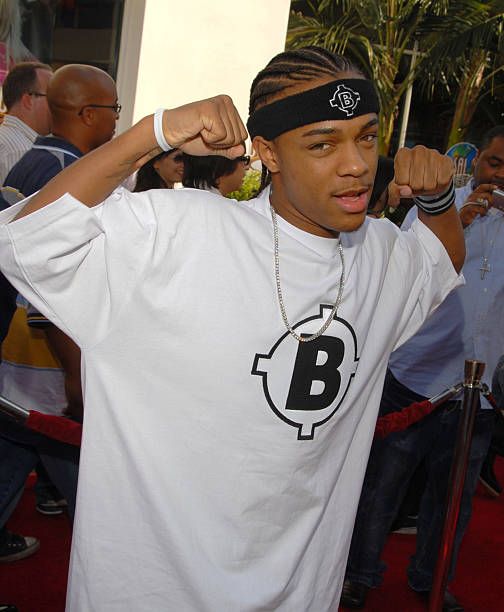 a young man wearing a white shirt and black headband is posing for the camera