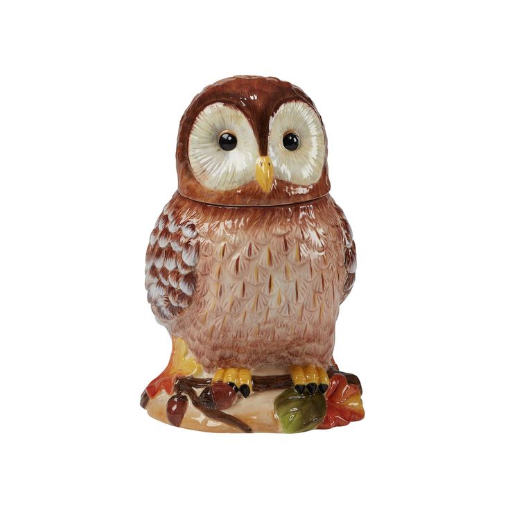 an owl figurine sitting on top of a tree branch