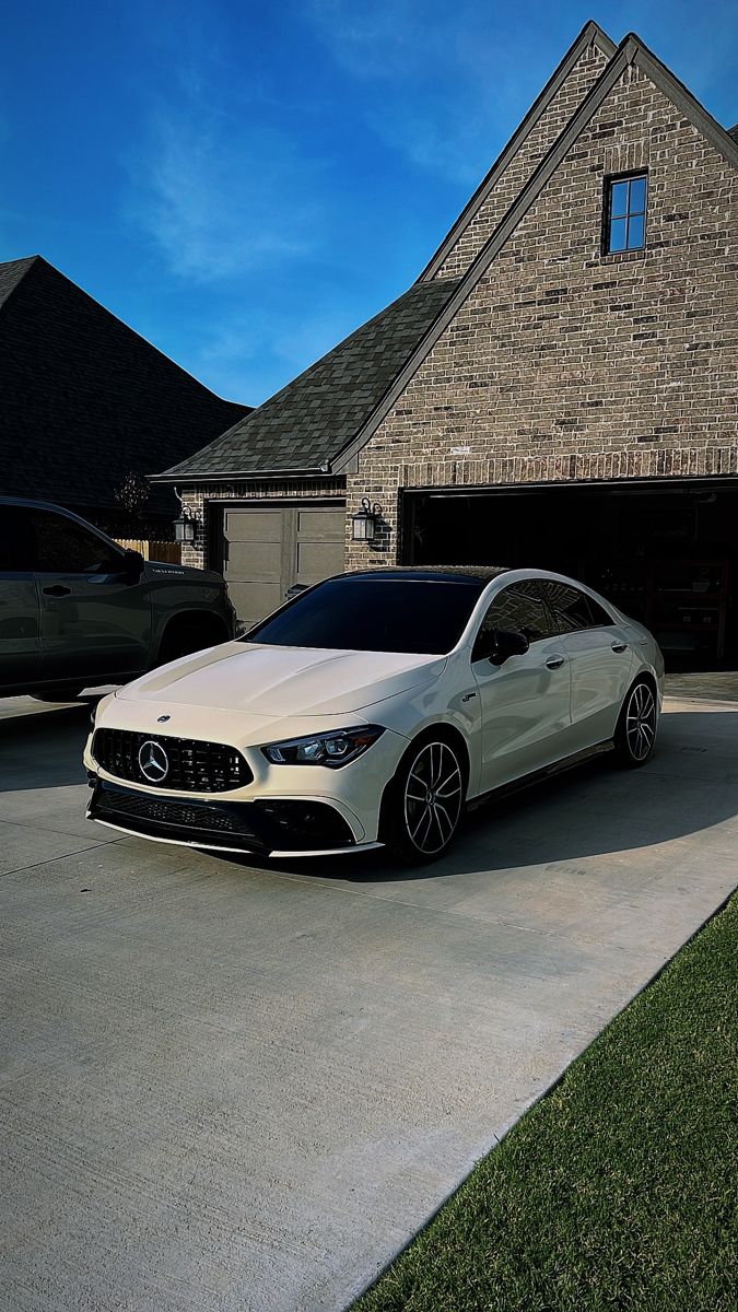 a white car parked in front of a house