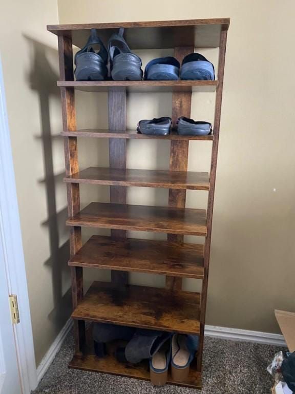 a wooden shelf with several pairs of shoes on it in a room next to a door