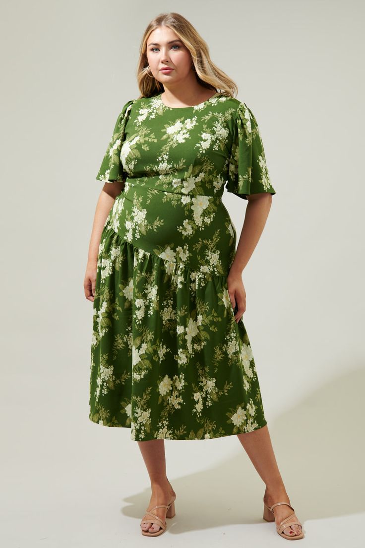 An ethereal floral print takes on a timeless silhouette with a modern taste. The Vetiver Floral print features bright, summer motifs that sit against a green-ground that decorates the Rhythm midi. A dress that features flouncy short sleeves that frame a flattering, fitted bodice that maintains a sleek fit throughout the waist, nearing the hips. A drop waist, asymmetrical skirt sits low on the hips, reminiscent of the twenties and thirties. Wear it with kitten heels and your fave bag.- Drop waist Green Printed Midi Dress For Garden Party, Garden Party Green Printed Midi Dress, Green A-line Midi Dress With Floral Print, Spring Green Printed Midi Dress, Green A-line Floral Dress For Garden Party, Green Short Sleeve Midi Dress For Brunch, Green Floral Print Midi Dress, Green Printed Floral Dress For Garden Party, Green Floral Printed Dress For Garden Party