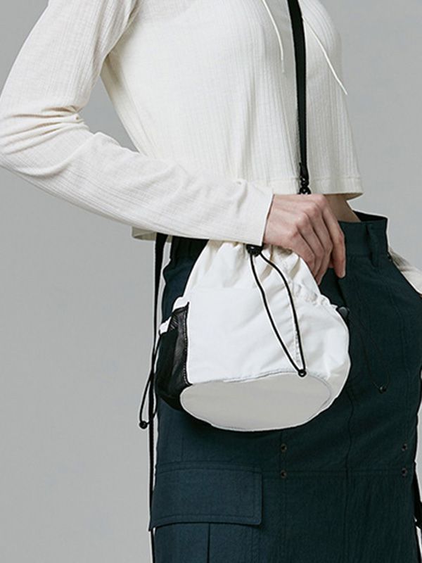 This is a casual and comfortable mini bucket bag that is made out of high quality polyester and nylon 100% fabric. With design detail of detachable cross strap and logo print on the back, it gives a trendy and casual mood.- Matte texture of nylon fabric- 3M elastic string and logo print on the back - Detachable cross strap White Crossbody Bucket Bag For On-the-go, Trendy White Shoulder Bag For Outdoor, White Bucket Shoulder Bag With Mobile Phone Pocket, Casual Bucket Bag With Mobile Phone Holder, White Bucket Shoulder Bag With Phone Pocket, White Shoulder Bucket Bag With Mobile Phone Pocket, White Shoulder Bucket Bag With Phone Bag, Spring Bucket Bag For On-the-go, White Mobile Phone Bucket Shoulder Bag