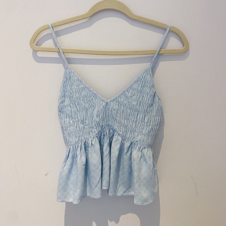 Condition: Never Before Worn, Original Tags Intact Style: Sleeveless Pastel Blue Tank Top, V-Neck, Ruffle Accents, Ruched Bust, Embroidered Design Brand: Cotton Candy La Fabric: 100% Rayon Size: Us Medium, Fits True To Size, Flexible To Various Bust Sizes Due To Elasticity Completly Sold Out Online Light Blue Camisole Tank Top For Spring, Ruched Tank Top For Summer, Ruched Sleeveless Blouse Tank Top For Summer, Blue Cotton Tank Top With Ruffles, Spring V-neck Tank Top With Ruffles, Light Blue Sleeveless Blouse Tank Top For Spring, Light Blue V-neck Tank Top For Summer, Light Blue Camisole For Spring, Light Blue Fitted Camisole For Summer