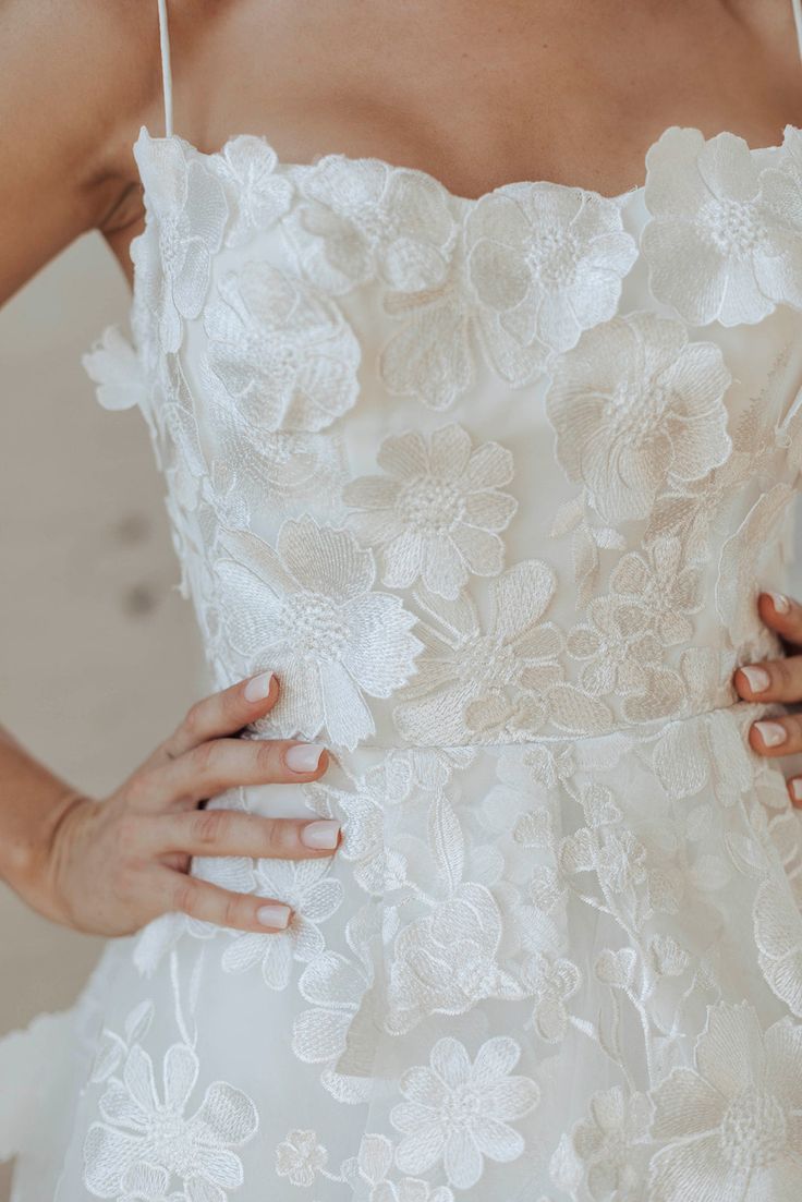 a woman in a wedding dress holding her hand on her hip