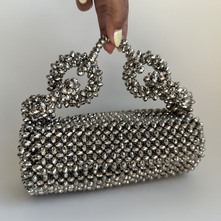 The Georgia Silver Bag is not just an accessory; it’s a statement piece that promises to elevate your style and add a touch of sophistication to any outfit. Whether you’re attending a formal event or a casual gathering, this bag is versatile enough to complement any occasion. Designer Party Shoulder Bag With Top Carry Handle, Luxury Top Handle Shoulder Bag For Events, Designer Party Bags With Removable Pouch, Chic Rectangular Clutch With Silver-tone Hardware, Chic Handheld Shoulder Bag With Silver-tone Hardware, Evening Satchel With Pearl Handle, Evening Satchel Bag With Pearl Handle, Chic Clutch Evening Bag With Silver-tone Hardware, Chic Evening Clutch With Silver-tone Hardware