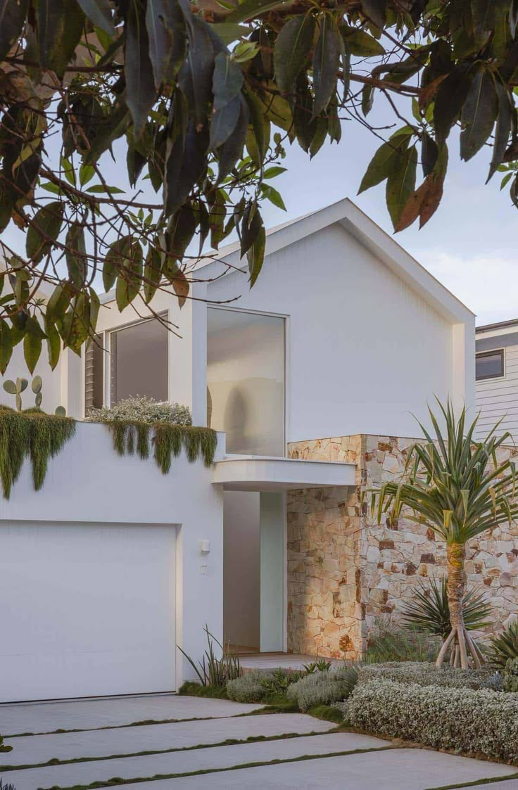 a white house surrounded by trees and plants