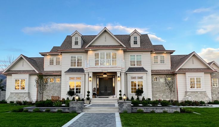 a large white house sitting on top of a lush green field