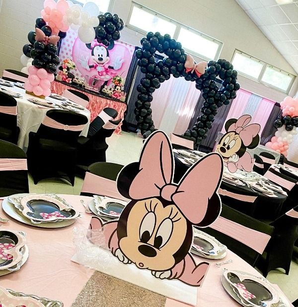 a minnie mouse themed party with balloons and tables in the shape of mickey mouse's head