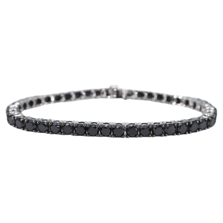 The item in question is a luxurious bracelet adorned with 44 black diamonds, boasting a total weight of 16.50 carats. The diamonds are cut in the brilliant style, which enhances their sparkle and light reflection. The color of the diamonds is a rich black, with an opaque appearance that has been enhanced to achieve a deeper shine. The quality of the cut is regarded as very nice, suggesting that the diamonds have been skillfully shaped to maximize their brilliance. The bracelet is crafted from 14 karat gold, with a hallmark confirming its authenticity. It has a total weight of 17.5 grams, indicating a substantial but comfortable piece. The bracelet measures 18.5 cm in length, making it suitable for most wrist sizes. This item is in new condition, with no visible signs of wear, and the quali Luxury Black Diamond Bracelet With Round Shape, Black Diamond Round Bracelet, Elegant Black Tennis Bracelet With Jubilee Style, Black Diamond Bracelet With Diamond Accents, Black Diamond Bracelet With Accents, Classic Round Black Diamond Bracelet, Elegant Black Diamond Tennis Bracelet, Classic Tennis Bracelet With Black Diamonds For Formal Occasions, Elegant Black Diamond Bracelet Gift