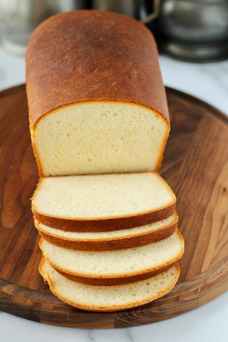 sliced loaf of bread sitting on top of a wooden cutting board