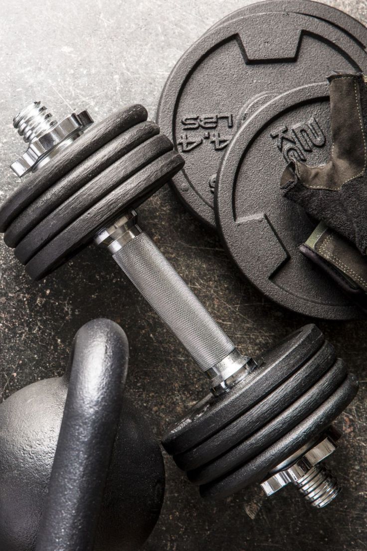 dumbbells and gloves on the ground next to each other