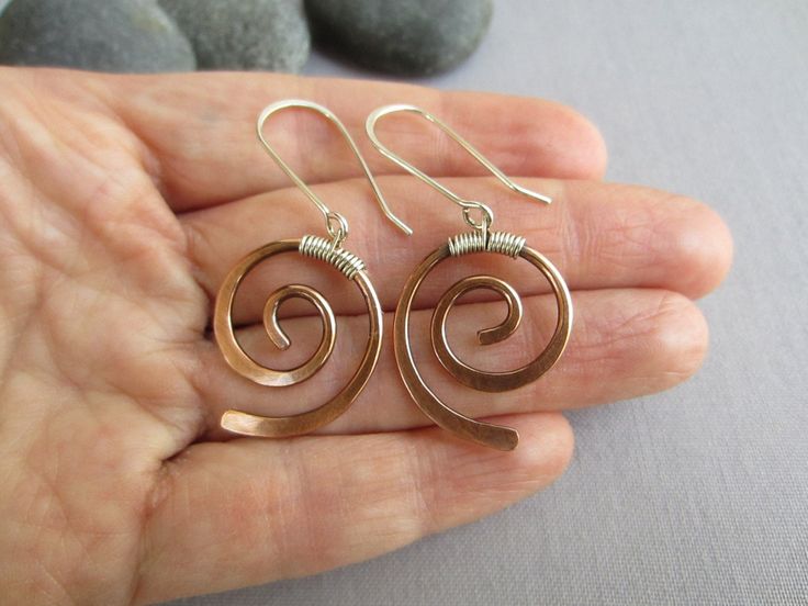 "Forever popular spiral earrings with a modern twist for everyday use. I created these earrings to have a nice neutral, casual, lightweight jewelry which is a little bit unusual since I like very much the unusual The copper wire was hand forged and hammered to get spiral shape which is decorated with a silver wire wrap on the top part. The wrap has a loop so the ear wire can be attached to it. I made the ear wire long to give a modern touch to the design. For the ear wire I used Sterling Silver Copper Wire Earrings, Wire Wrapped Jewelry Diy, Mixed Metal Earrings, Light Weight Jewelry, Wrap Earrings, Wire Jewelry Designs, Spiral Shape, Hammered Earrings, Wrapped Earrings